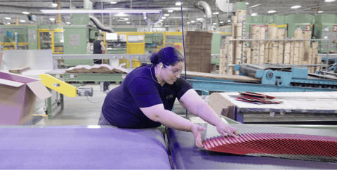 Woman loading boxes onto conveyor belt. Woman loading boxes onto conveyor belt.